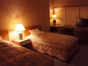 a hotel room with two beds and a desk at Usyounoie Sugiyama in Gifu