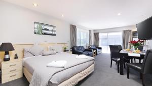 um quarto com uma cama, uma secretária e uma sala de jantar em Arthur's Court Motor Lodge em Christchurch
