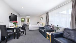a living room with a couch and a table at Arthur's Court Motor Lodge in Christchurch