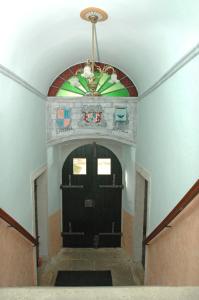 a hallway with a black door with a stained glass window at Apartments Lazzarini Battiala in Nedeščina