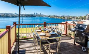 a table and chairs on a deck with an umbrella at Cockatoo Island Accommodation in Sydney