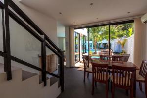 a dining room with a table and chairs and a patio at Sai Naam Lanta - Apartments & Townhouses in Ko Lanta