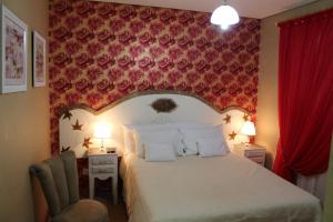 um quarto com uma cama e uma parede vermelha em Pousada Suisse em Campos do Jordão