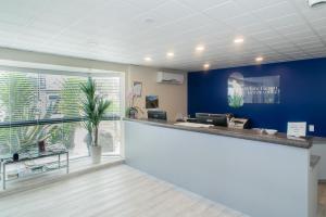 una oficina con una pared azul y un mostrador de recepción en White Heron Motor Lodge, en Gisborne