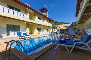 uma piscina com cadeiras e um hotel em Baan Chaylay Resort Karon em Praia de Karon