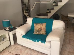 a white couch with a blue blanket on it at Casa Riviera de São Lourenço in Riviera de São Lourenço