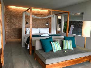 a bedroom with a canopy bed and a bench with pillows at Umadewi Surf & Retreat in Pulukan