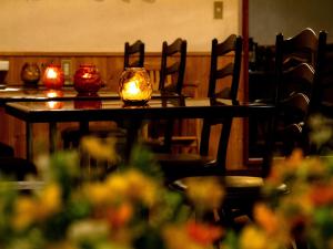 a table with candles on it with chairs and flowers at Kagura White Horse Inn in Yuzawa