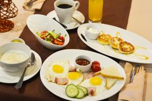 tres platos de desayuno en una mesa en Gavan Hotel, en Vladivostok