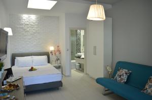 sypialnia z łóżkiem i niebieską kanapą w obiekcie Aqua Luxury Villas w mieście Nea Potidaea