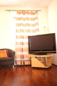 a living room with a flat screen tv and a couch at Kukucinova Apartments in Bratislava