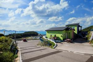 a yellow and green building next to a street at 13 Ohoo in Namhae