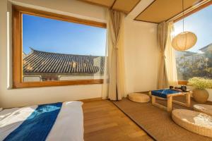 um quarto com uma grande janela com vista para um edifício em Dali Xian Jing Courtyard Inn em Dali