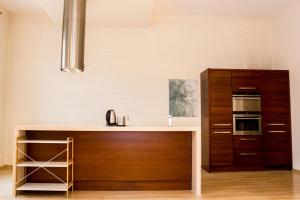 クラクフにあるSauna Luxurious Apartmentのキッチン(木製カウンタートップ、キャビネット付)