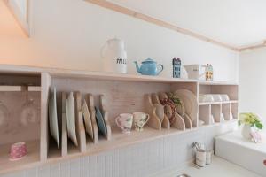 a shelf filled with dishes and vases on a wall at 13 Ohoo in Namhae