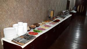 Hotel Diyora في سمرقند: طابور بوفيه طويل مع الطعام على طاولة
