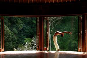 a woman dancing in front of a window at Bagus Jati Health & Wellbeing Retreat in Tegalalang