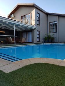 uma grande piscina em frente a uma casa em A' Queenslin Guesthouse em Paarl