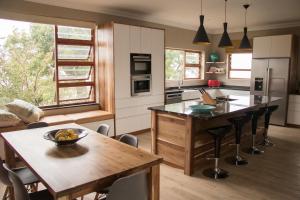 a kitchen with a wooden table and a dining room at A' Queenslin Guesthouse in Paarl