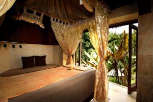 a bedroom with a bed with curtains and a window at Bagus Jati Health & Wellbeing Retreat in Tegalalang
