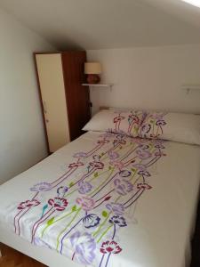 ein Schlafzimmer mit einem Bett mit Blumenmuster darauf in der Unterkunft Apartment STAR in Novalja