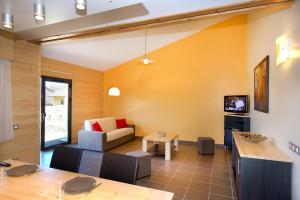 ein Wohnzimmer mit einer Couch und einem Tisch in der Unterkunft Les Hauts du Gevaudan in Montrodat
