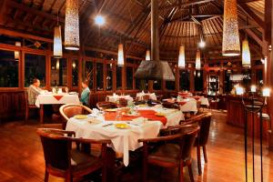 a dining room with tables and chairs in a restaurant at Bagus Jati Health & Wellbeing Retreat in Tegalalang