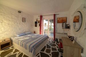 a bedroom with a bed and a table and a window at Koundouros Vacation Homes in Koundouros