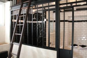 une chambre avec une cellule revêtue de carrelage noir et blanc dans l'établissement l'Atelier de Saint-Just, à Lyon