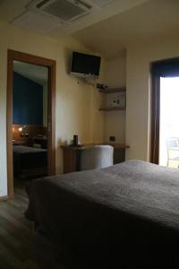 a hotel room with a bed and a television at Hotel La Meridiana in Anghiari