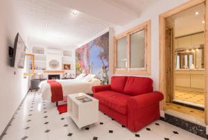 Un dormitorio con una cama y un sofá rojo. en Salamandra Plaza, en Cómpeta