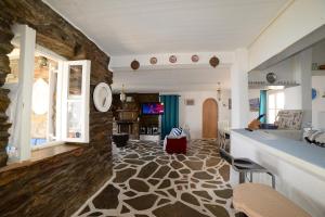 una gran sala de estar con una pared de piedra. en Koundouros Vacation Homes, en Koundouros