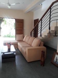 a living room with a couch and a staircase at Kelaniya Heritage in Kelaniya