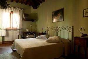 sypialnia z łóżkiem z białą pościelą i oknem w obiekcie Agriturismo Fattoria Rozzalupi w mieście Cerreto Guidi +37 zdjęć