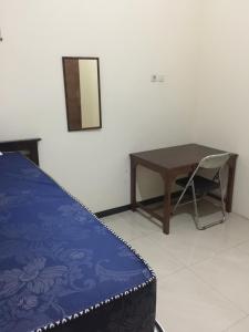 a bedroom with a desk and a table and a chair at Rumah Nyaman Back Packer in Semarang