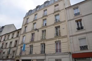 un grand bâtiment avec de nombreuses fenêtres donnant sur une rue dans l'établissement Hôtel Richard, à Paris