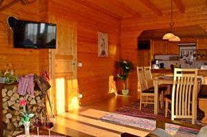 comedor con mesa y TV en una cabina en Bayerwaldblockhaus en Philippsreut