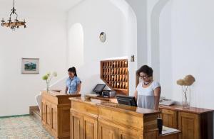 two women standing at a desk in a room at Hotel Pupetto in Positano