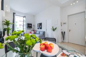 a table with a plate of fruit on it in a living room at Lovely Cenisio Apartment in Milan