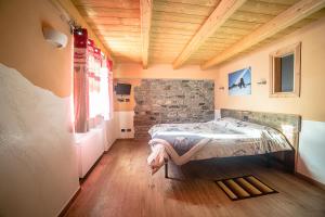 a bedroom with a bed and a stone wall at Alpe Rebelle in Bionaz