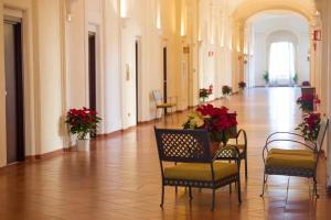 a hallway with chairs and flowers in a building at Domus Sessoriana in Rome