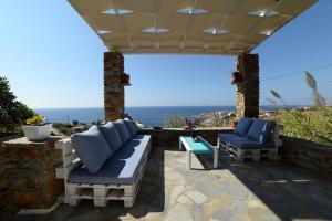 a patio with a couch and two chairs and a table at Koundouros Vacation Homes in Koundouros
