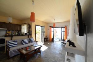 sala de estar con cama y cocina en Koundouros Vacation Homes, en Koundouros
