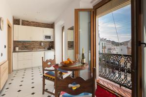 a kitchen with a table and a balcony at Salamandra Plaza B&B in Cómpeta