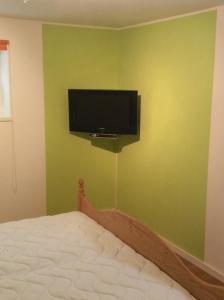 a bedroom with a bed and a flat screen tv on the wall at Haus am Treffenbach in Waldmünchen