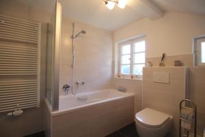 een badkamer met een bad, een toilet en een wastafel bij Alpenschloss in Garmisch-Partenkirchen