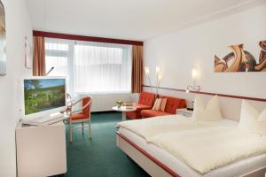 a hotel room with a bed and a living room at Hessen Hotelpark Hohenroda in Hohenroda