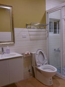 a bathroom with a toilet and a sink and a shower at Exotic Wind Sand City 86台東民宿 編號1368 in Taitung City