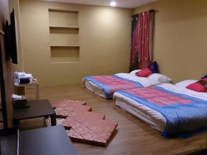 a bedroom with two beds and a table and a tv at Exotic Wind Sand City 86台東民宿 編號1368 in Taitung City