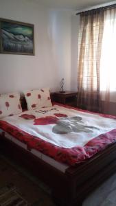 パンポロボにあるSki apartment in Monastery 3 complexのベッドルーム1室(赤い花の大きなベッド1台付)